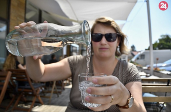 Žena nalieva vodu z fľaše počas horúceho dňa